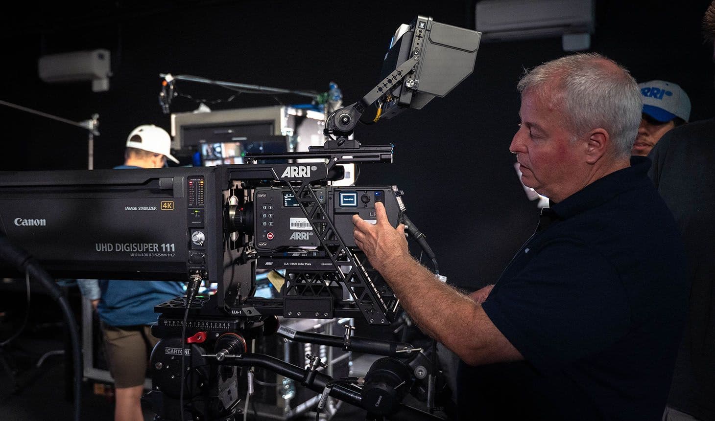 An ARRI technician fitting a Canon UHD DIGISUPER 111 box lens to an ALEXA 35 Live using an ARRI LLA-1 lens adapter.